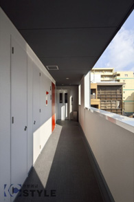 玄関扉が黒・赤と鮮明に生える共用部廊下