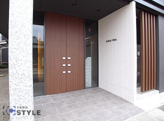 建物西側に位置するマンション入口タイル張りでモダンな館銘板