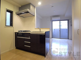 シックな黒いキッチンと明るいフローリング色がお洒落です