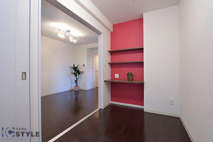 ダブルベッドが入る寝室には各室異なったポイントカラーのクロスをあしらったパソコンデスクになる棚収納付き