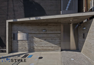 杉板の木目が美しいコンクリート打ちっ放しに、オシャレなメールBOXに隠れ家テイストな集合ドア